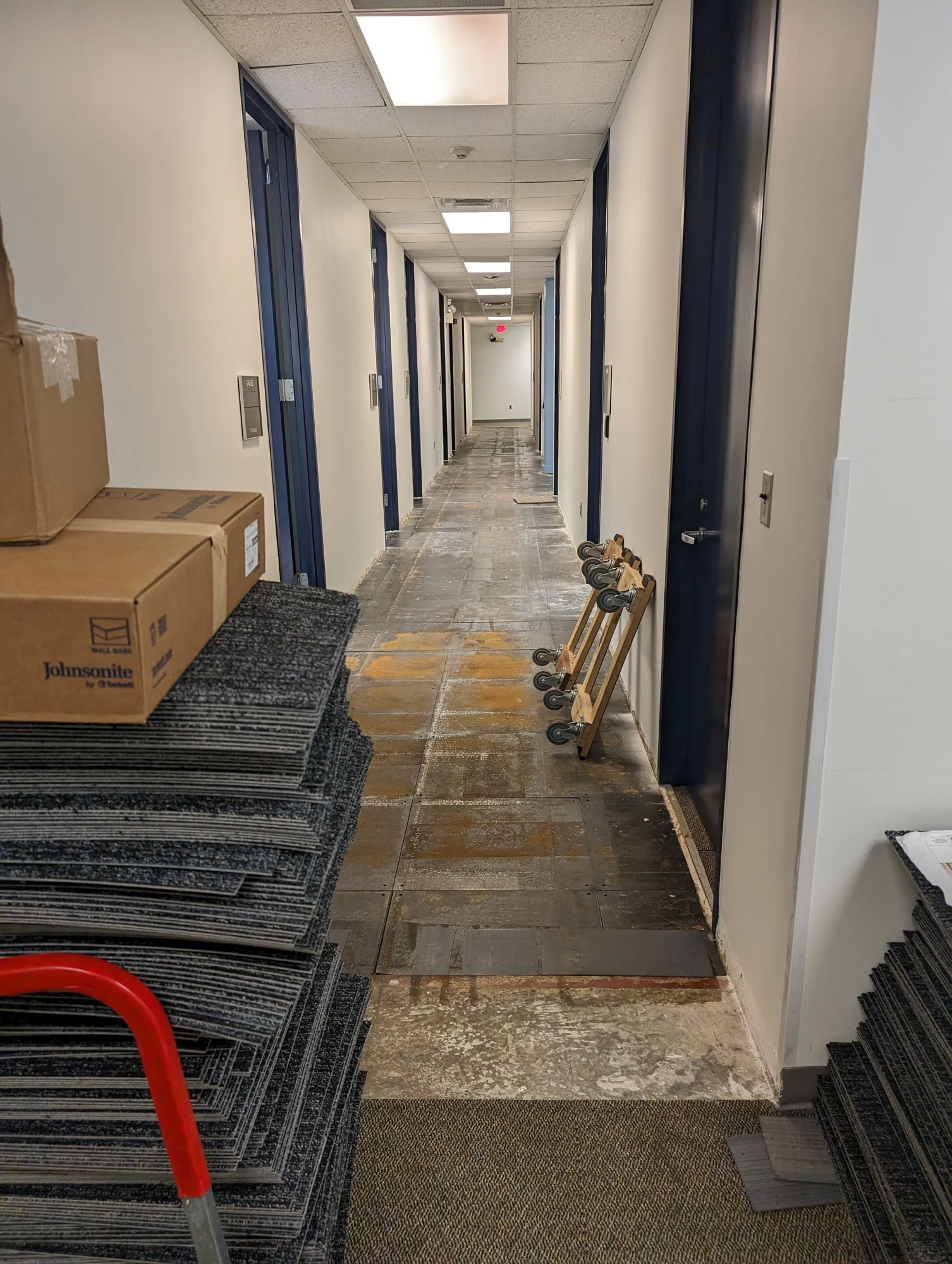 New carpet being installed along the XL hallway, with materials and unfinished work visible